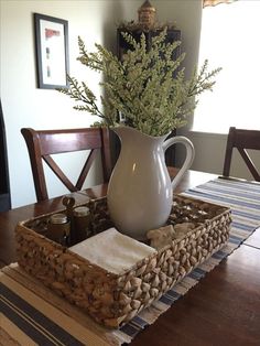 a white pitcher sitting on top of a wooden table