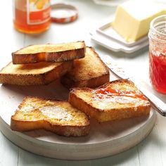 toasted bread with ketchup on a plate next to butter and jams