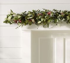 the door is decorated with greenery and pink flowers on it's side rail