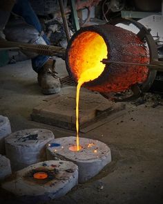 a person pouring liquid into a metal container