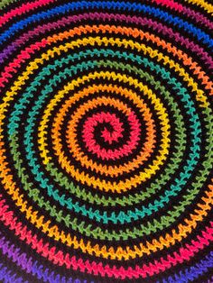 a multicolored circular crochet pattern on a black background