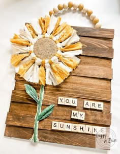 a sunflower made out of scrabbles on a wooden board with words