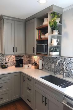 a kitchen with gray cabinets and white counter tops, an oven, microwave and dishwasher