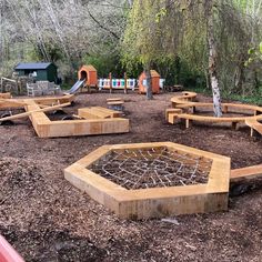 an outdoor play area with wooden benches and climbing equipment in the background, surrounded by trees