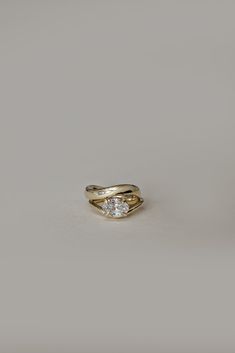 a gold ring with two diamonds on the top, and one diamond in the middle