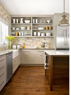 a kitchen with white cabinets and wooden floors