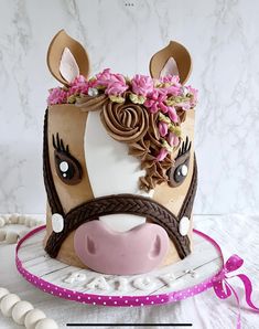 a cake that looks like a cow with flowers on it's head and ears