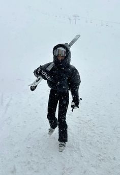 a person walking in the snow with skis on their back