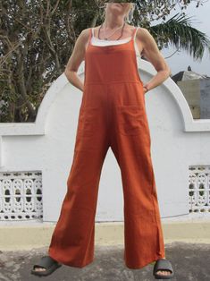 Organic cotton dungarees in burnt orange. Stylish, comfortable and easy to wear, these flared cotton dungarees are made from soft, light handwoven 100% organic cotton.   With a back fastening adjustable strap and loop and two front pockets and two back pockets. Perfect for spring until autumn, and cool in the summer these cotton dungarees will look good any time. Made from handwoven organic cotton which has been woven using traditional weaving methods. Sourced from artisans via a small co-operat Brown Cotton Overalls For Spring, Cotton Bib Front Overalls In Solid Color, Solid Cotton Bib Front Overalls, Cotton Overalls With Bib Front, Solid Cotton Overalls With Bib Front, Brown Cotton Relaxed Fit Jumpsuits And Rompers, Brown Cotton Overalls With Pockets, Brown Cotton Overalls, Summer Orange Cotton Jumpsuits And Rompers