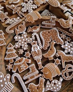 some very pretty decorated cookies on a wooden table with other items in the shape of animals