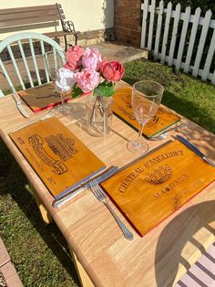 a wooden table topped with two place settings