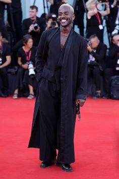 a man standing on top of a red carpet