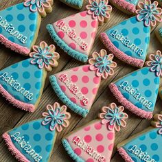 decorated cookies are arranged in the shape of birthday hats with blue and pink frosting