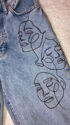 a pair of jeans with faces drawn on them