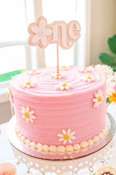 a pink cake sitting on top of a table