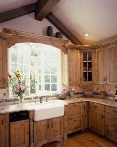 a large kitchen with wooden cabinets and white counter tops, an open window over the sink