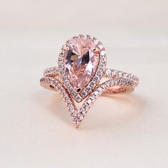 Rose Gold Halo Pear Cut Synthetic Morganite Wedding SetEmbedding diamonds by handcraft. Exquisite design made perfect for an engagement ring, wedding ring, promise ring, bridal ring set, anniversary ring, couples ring, and more. Wonderful gifts for birthdays, Mother's Day, Valentine's Day, Thanksgiving, Christmas, and all other occasions.Our mission is to create premium stones that shine like a natural diamond. Gemstone types, shapes, colors, and cuts were carefully designed and handcrafted to p Rose Gold Ring With Pink Diamond, Morganite Wedding Set, Morganite Jewelry, White Stone Ring, Pear Halo, Couples Ring, Rose Gold Halo, Rose Gold Morganite, Diamond Alternatives