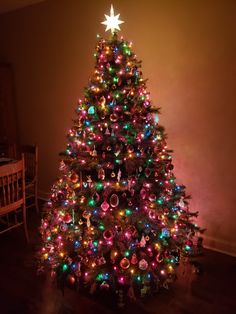 a brightly lit christmas tree in the corner of a room