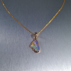 Solid carved Lightning Ridge crystal opal, set in a 14ct yellow gold pendant.  Chain not included. Opal Weight: 2.0ct Size: 16x8.8mm Pendant Length: 26mm Width: 10mm Depth: 4.5mm Materials: Lightning Ridge solid opal, 14ct yellow gold   Total Weight: 1.6gm Opal Cabochon Yellow Gold Jewelry, Yellow Gold Opal Cabochon Jewelry, Yellow Gold Ethiopian Opal Cabochon Jewelry, Opal Jewelry With Polished Finish For Gift, Gold Ethiopian Opal Cabochon Jewelry, Gold Opal Pendant Jewelry, Iridescent Opal Pendant Jewelry, Polished Opal Pendant Jewelry, Formal Gold Ethiopian Opal Jewelry