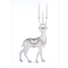 a white deer figurine with four candles in it's mouth and one standing on its hind legs