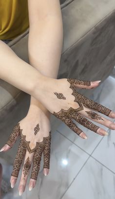 two hands with henna tattoos on them