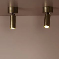 three lights are hanging from the ceiling in a room with beige walls and flooring