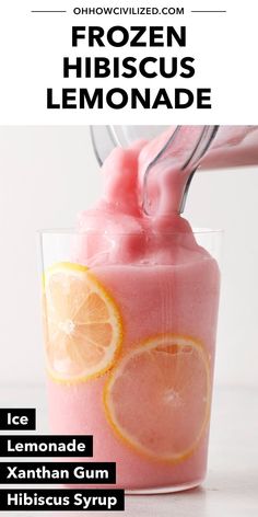 a pink drink in a glass with ice and orange slices on top, next to the text frozen hibiscus lemonade