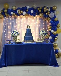 a blue table topped with a cake and balloons