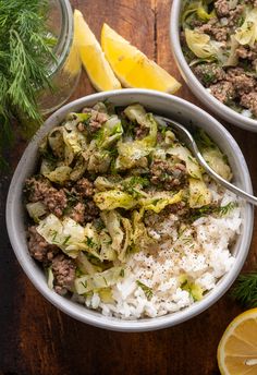 two bowls filled with meat and vegetables on top of rice next to lemon wedges