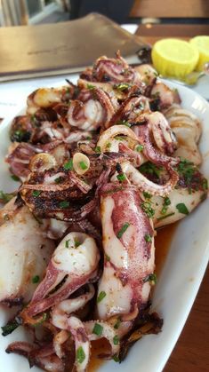 an octopus dish is served on a white plate