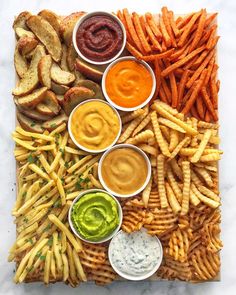 a platter filled with fries, dips and sauces on top of each other