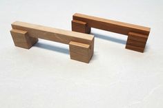 two wooden benches sitting next to each other on a white surface with no one around them