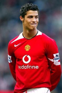 a man in a red shirt standing on a soccer field