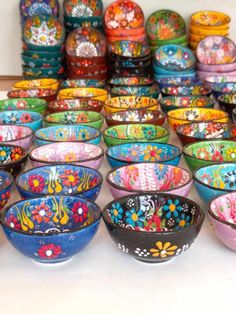 many colorful bowls are lined up on the floor and ready to be used as decorations