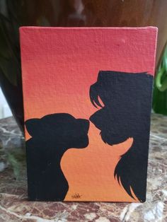 a painting of two dogs kissing on an orange and black background with the silhouettes of their heads