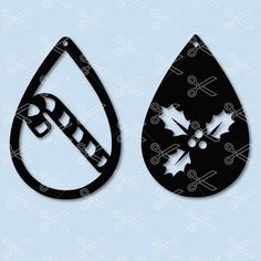 two tear shaped paper cut outs with holly leaves and snowflakes on them, one is black and the other is white