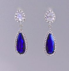 "Would you love to sparkle even brighter on your special day? Looking for your something Blue? Gorgeous bridal earrings have been created using a long sapphire blue crystal in a cz halo and are completed by your choice of earpost. Perfect for the Mother of the bride. Style #1~ Art Deco-inspired earpost. CZ crystals studded in a double swirl. Style #2~ Teardrop Earpost -pearl CZ crystal in a halo of smaller crystals. Post back Style #3~ Smaller Teardrop earpost, inverted pear crystal with a halo Blue Drop Bridal Earrings For Formal Events, Blue Drop Bridal Earrings For Formal Occasions, Blue Drop Earrings For Bridal Formal Occasion, Blue Sterling Silver Earrings For Wedding, Blue Drop Earrings For Formal Bridal Wear, Blue Drop Earrings For Wedding, Blue Dangle Bridal Earrings For Formal Occasions, Blue Drop Jewelry For Wedding, Formal Blue Dangle Bridal Earrings