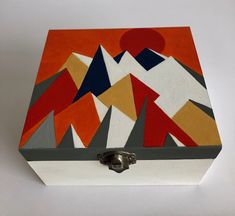 a box with an abstract painting on the lid and handles, sitting on a white surface