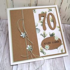 a close up of a greeting card with flowers and leaves on the front, in brown paper