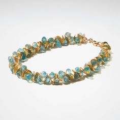 Gold & Stone Bracelet - Aqua apatite beads nestle between 22K gold vermeil disks in this bracelet with a delicate, feminine design and subtle sparkle. 14K gold-filled clasp. <br>Approximately 0.5W<br><br>The artist offers half sizes from 7- 8-1/2 long. Please indicate desired bracelet length below.<br><br>To find your correct size, measure your wrist over the bone, then add 1 to get bracelet length. Bracelet Design Ideas, Pearl Earring Jacket, Electric Blue Color, Apatite Jewelry, Mini Bracelet, Earrings Dangle Simple, Signature Bracelet, Delicate Feminine, Paraiba Tourmaline