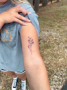 a woman with a flower tattoo on her arm