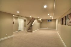 an empty room with carpet and stairs