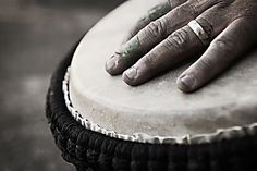 a person's hand resting on top of a drum