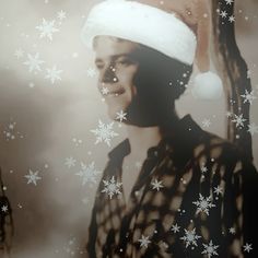 a man wearing a santa hat in front of snowflakes