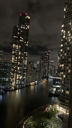 the city is lit up at night by the water