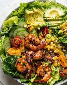 a white plate topped with salad and shrimp