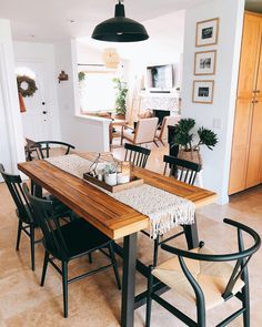 a dining room table with chairs and a light hanging over it