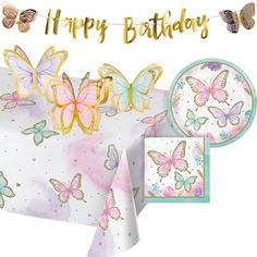 a table topped with plates and napkins covered in butterfly decorations next to a sign that says happy birthday