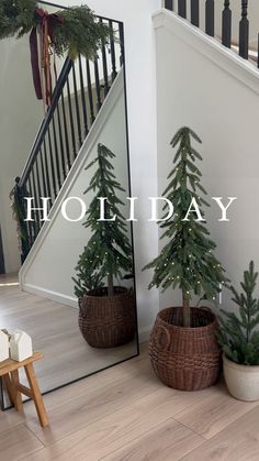 a christmas tree in a basket next to a mirror with the words holiday written on it