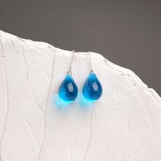 "These Small light blue teardrop earrings are made of glass in lampwork technique. The earrings hooks are sterling silver and are hypoallergenic. These unique and beautiful earrings are like water drops frozen in glass! They are simple and elegant, very lightweight and comfortable to wear, perfect for everyday wear and for special occasions. 💕 You will definitely receive lots of compliments on your new earrings, everybody loves them, and you'll love them too! Dimensions: total length about 1 1/ Blue Long Drop Teardrop Earrings With Ear Wire, Blue Pear-shaped Teardrop Earrings, Blue Teardrop Drop Earrings, Blue Teardrop Earrings With Ear Wire, Blue Long Drop Teardrop Earrings Gift, Blue Drop Earrings Hypoallergenic, Blue Hypoallergenic Teardrop Earrings As Gift, Hypoallergenic Blue Teardrop Dangle Earrings, Hypoallergenic Blue Teardrop Pendant Earrings